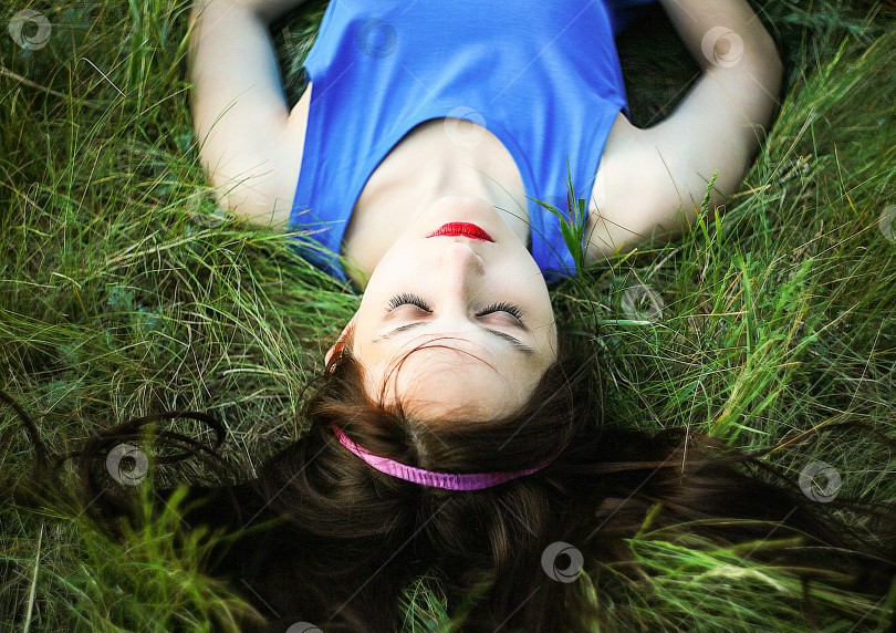 Скачать Красивая девушка лежит на траве фотосток Ozero