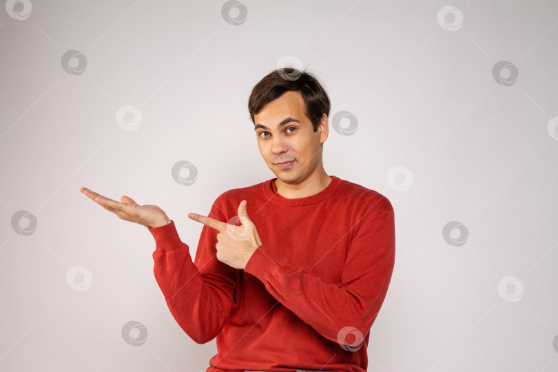 Скачать Парень в красном свитере указывает на свою руку фотосток Ozero