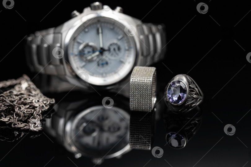 Скачать Различные оттенки серебра: титановые часы, серебряные кольца и цепочка фотосток Ozero