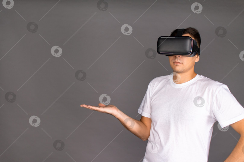 Скачать Парень в очках виртуальной реальности указывает на поле. Будущее и современные технологии. фотосток Ozero