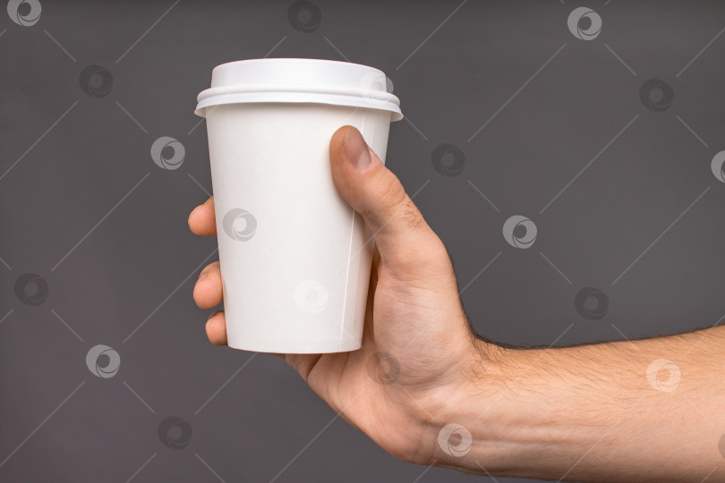 Скачать Макет чашки кофе в его руке на темном фоне фотосток Ozero