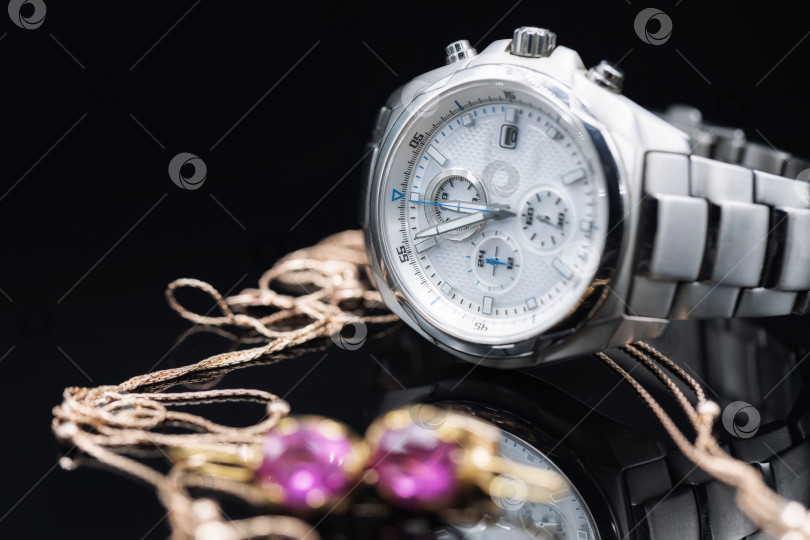 Скачать Солидные мужские часы с хронометром в титановом корпусе выделяются на фоне золотых женских украшений фотосток Ozero