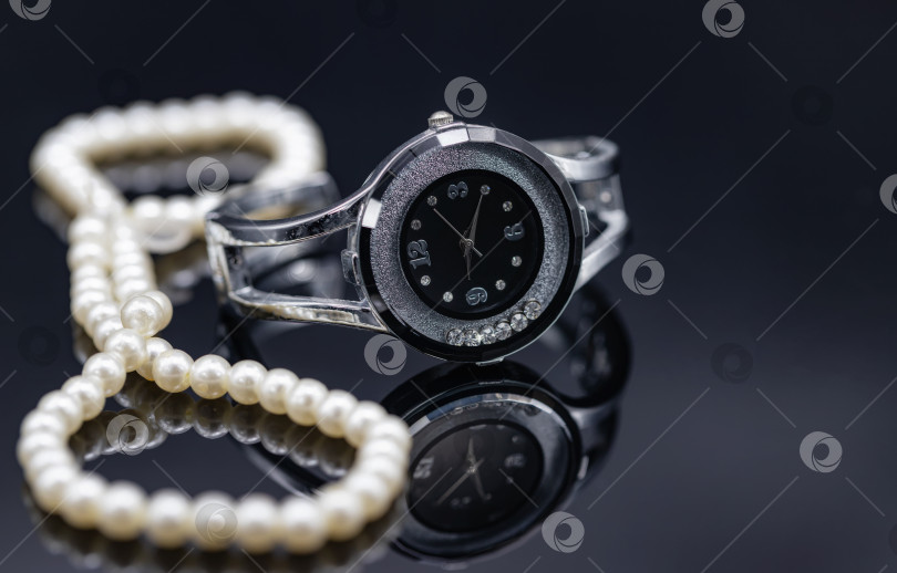 Скачать Женские часы в оригинальном металлическом корпусе и жемчужном ожерелье фотосток Ozero