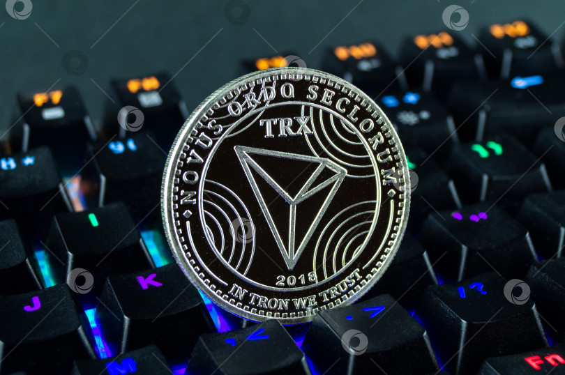 Скачать Монета cryptocurrency tron крупным планом с цветной клавиатурой. фотосток Ozero