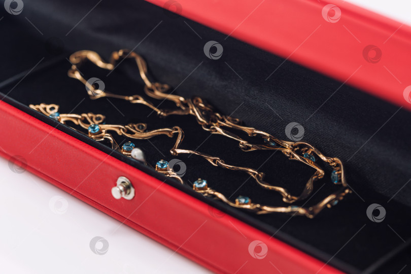 Скачать В подарочной коробке лежит элегантное золотое ожерелье с бирюзовым топазом фотосток Ozero