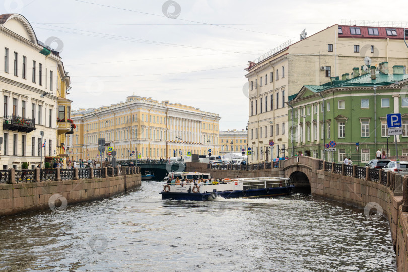 Скачать водный автобус маневрирует на реке Мойке в Санкт-Петербурге перед проездом под низким мостом фотосток Ozero