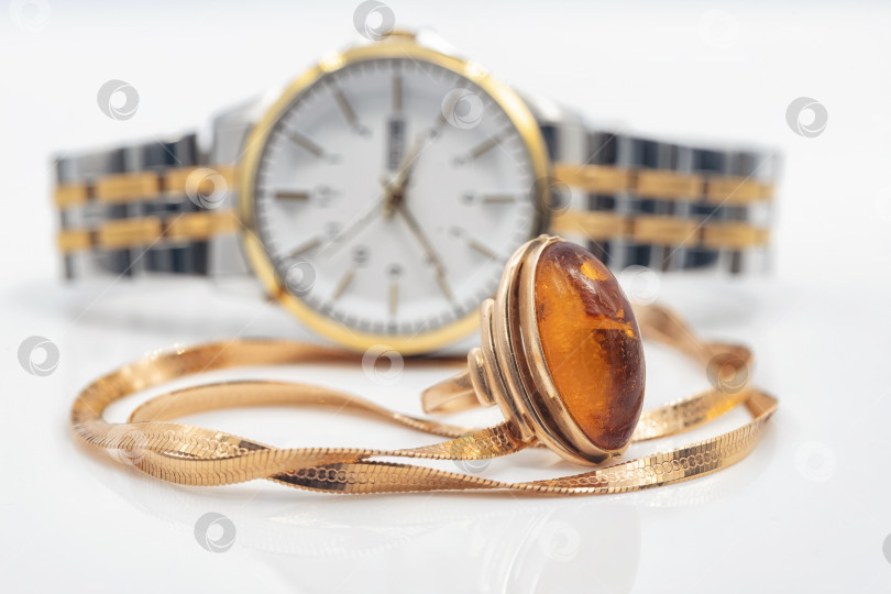 Скачать Элегантные женские наручные часы, золотая цепочка и крупное кольцо с янтарем фотосток Ozero
