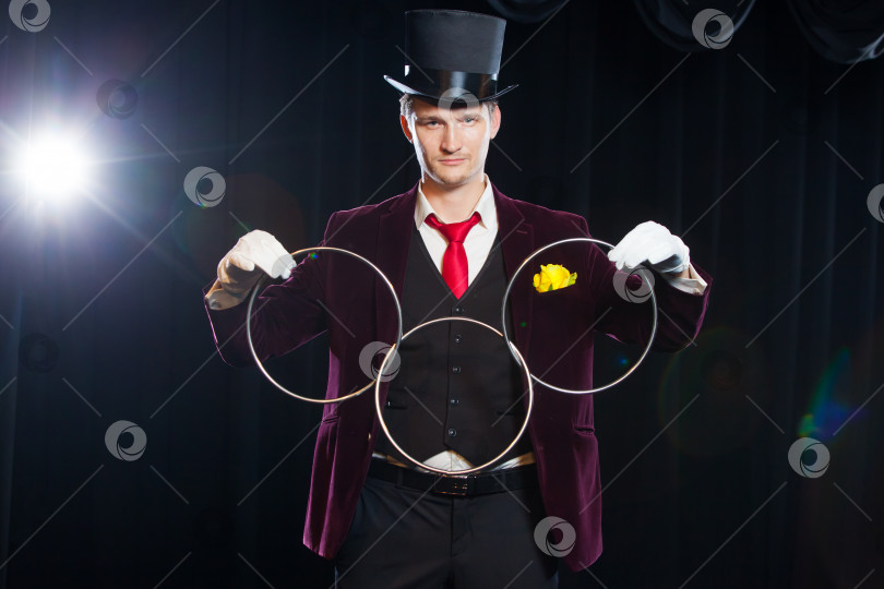 Скачать магия, представление, цирк, концепция шоу - фокусник в цилиндре показывает трюк со связующими кольцами фотосток Ozero
