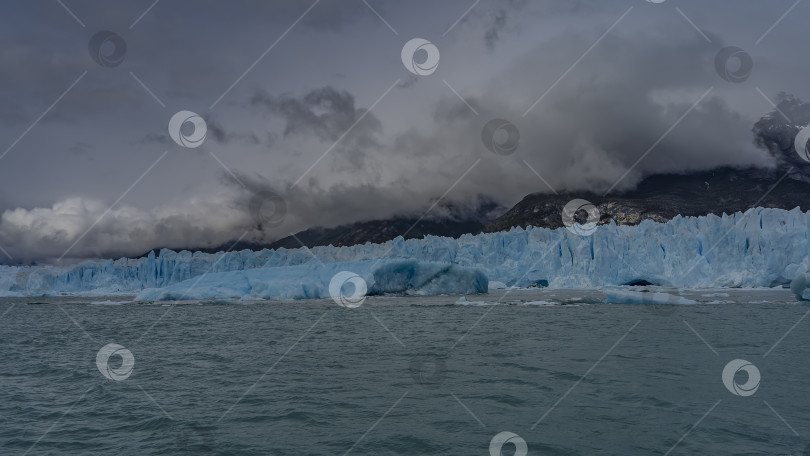 Скачать Стена голубого льда с трещинами и расселинами тянется в ледниковом озере. фотосток Ozero