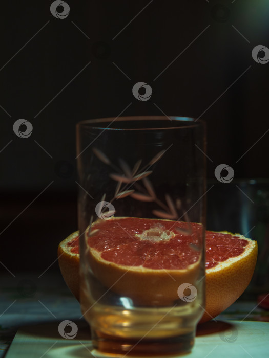 Скачать Пустой стеклянный бокал и половинка грейпфрута на столе, здоровая пища фотосток Ozero