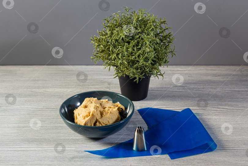 Скачать арахисовое масло в керамической миске и синий кондитерский мешок с насадкой для фигурного выкладывания начинки фотосток Ozero