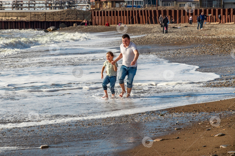 Скачать Отец и дочь весело проводят время на пляже. фотосток Ozero