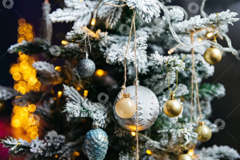 Скачать Рождественская елка с золотыми и серебряными шарами на ветвях. Украшения из рождественских гирлянд. Теплая гирлянда размытого боке. фотосток Ozero