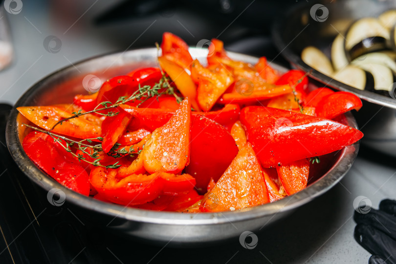 Скачать Крупные ломтики красного сладкого болгарского перца, намазанные маслом и приправами, например тимьяном. фотосток Ozero