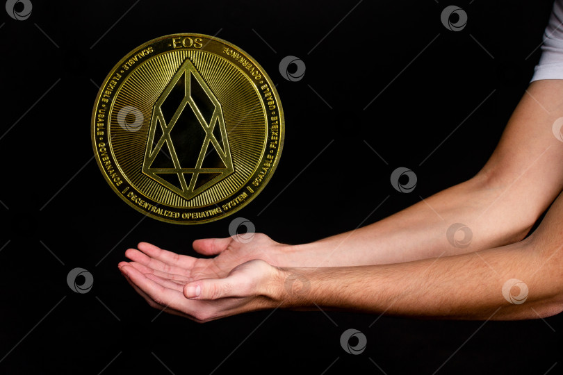 Скачать Символ новой популярной криптовалюты eosio с изображением рук фотосток Ozero