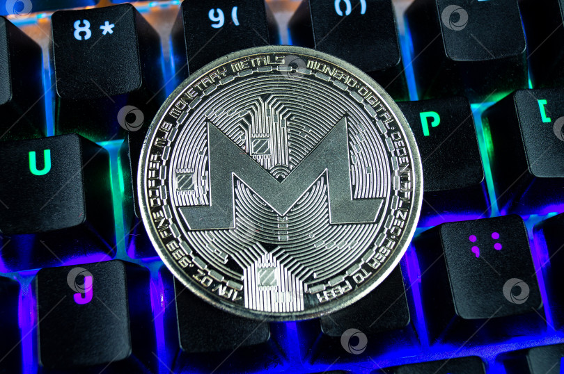 Скачать Монета криптовалюты monero крупным планом с цветовой кодировкой клавиатуры. фотосток Ozero