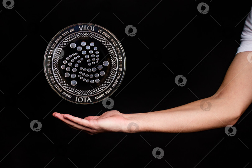 Скачать Элементы криптовалюты IOTA падают на руку. фотосток Ozero