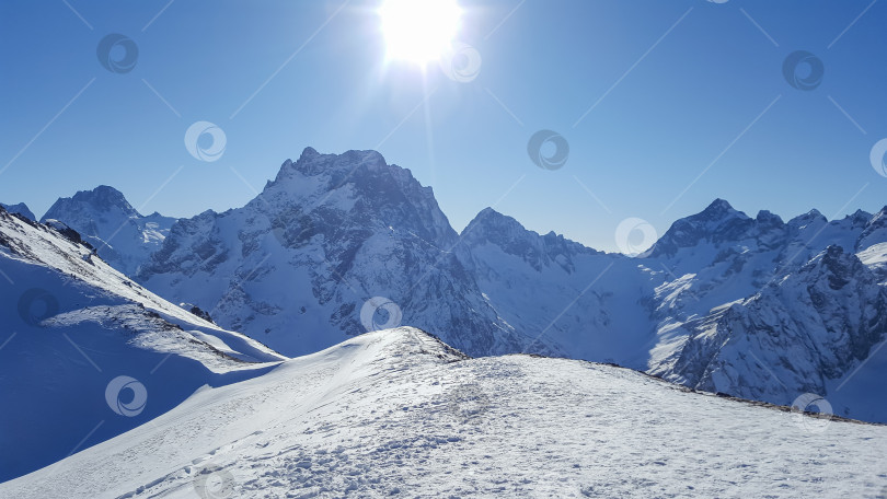 Скачать Заснеженные горные вершины в лучах солнца фотосток Ozero