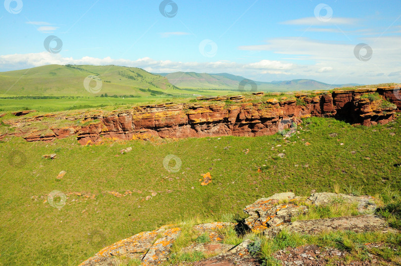 Скачать Остатки древнего каменного сооружения, идущего по вершине высокого и пологого холма солнечным летним днем. фотосток Ozero