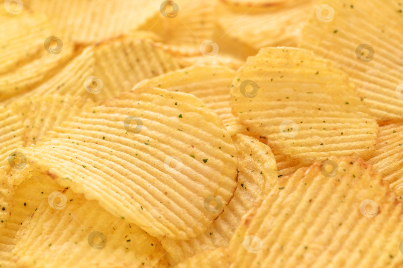Скачать Аппетитные хрустящие картофельные чипсы с текстурным фоном в селективном фокусе, фаст-фуд. фотосток Ozero