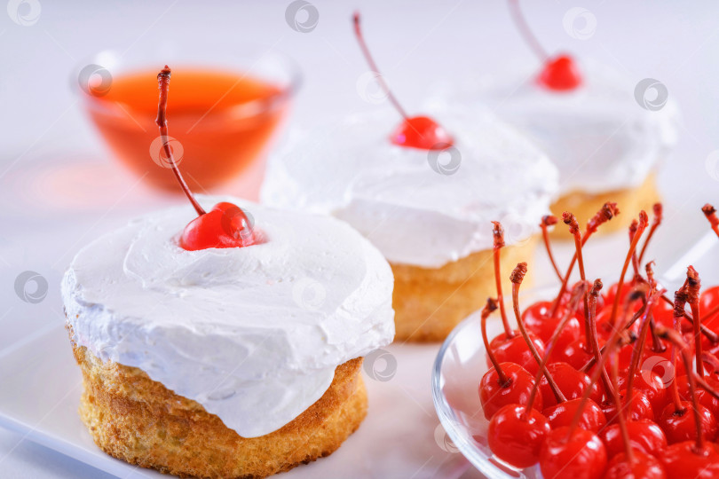 Скачать Бисквитный торт со сливочной глазурью и вишнями на тарелке. Вкусный торт, сладкий десерт. фотосток Ozero