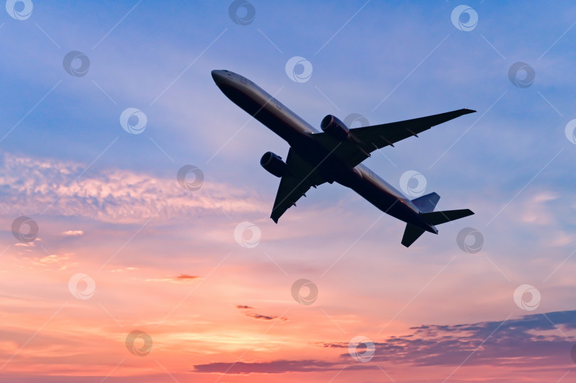 Скачать Пассажирский реактивный самолет летит над облаками на закате. Красивые пейзажи заката, концепция транспорта и быстрого путешествия. фотосток Ozero