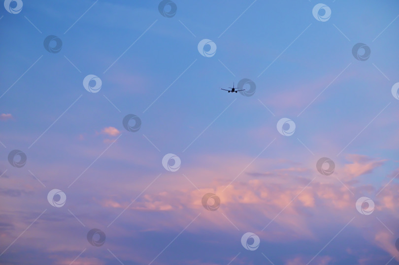 Скачать Пассажирский реактивный самолет летит над облаками на закате. Красивые пейзажи заката, концепция транспорта и быстрого путешествия. фотосток Ozero
