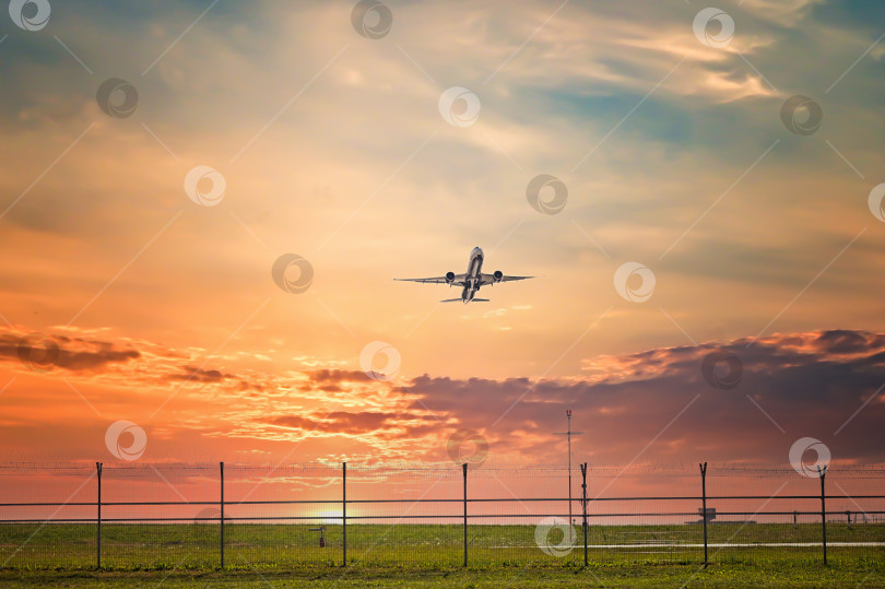 Скачать Посадка и взлет самолета на фоне разноцветного неба на закате. Пейзаж с летающими машинами парит в голубом небе с оранжевыми и розовыми облаками. Путешествующий на пассажирском самолете. фотосток Ozero