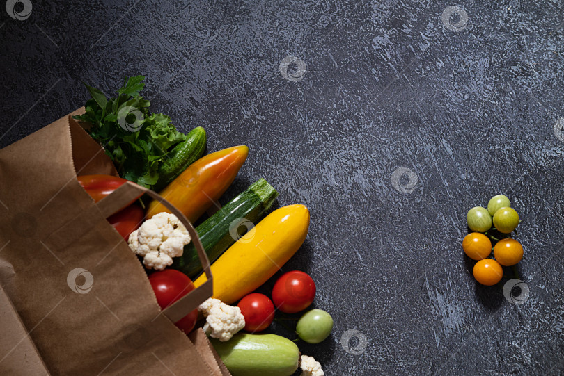 Скачать Бумажный пакет, полный различных полезных продуктов питания, выделенных на белом фоне. Вид сверху. фотосток Ozero