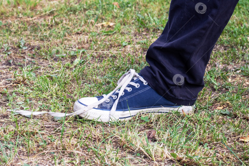 Скачать Шнурок на ботинке был развязан на траве фотосток Ozero