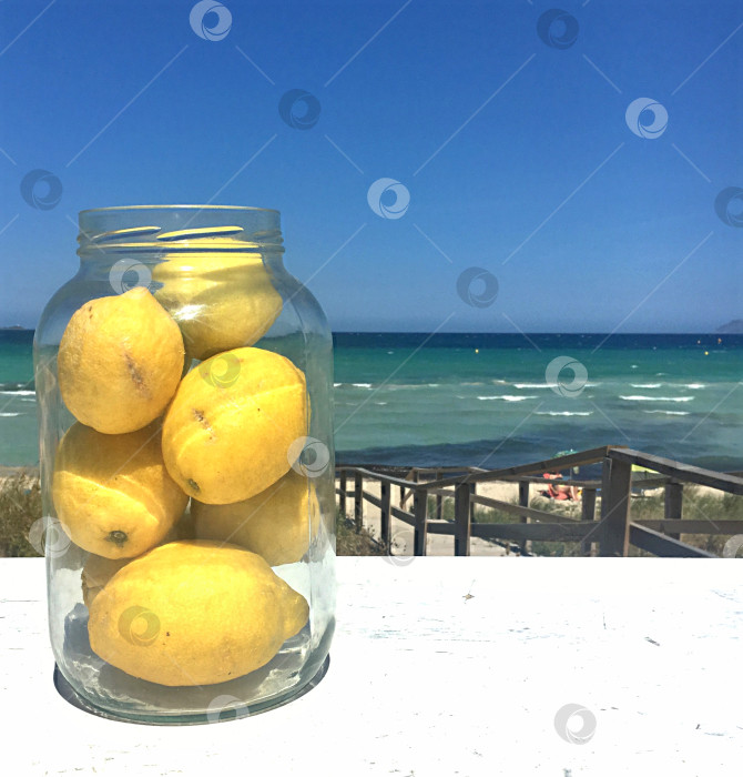 Скачать Банка с лимонами на фоне океана фотосток Ozero