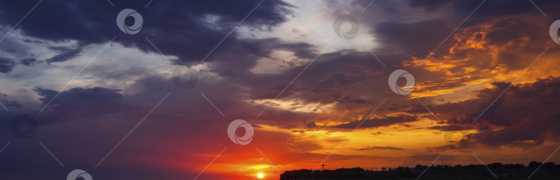 Скачать Красивый баннер на закате. Яркое красно-оранжевое небо на закате. Солнце, низко висевшее над горизонтом, своим светом раскрасило облака в разноцветные цвета фотосток Ozero