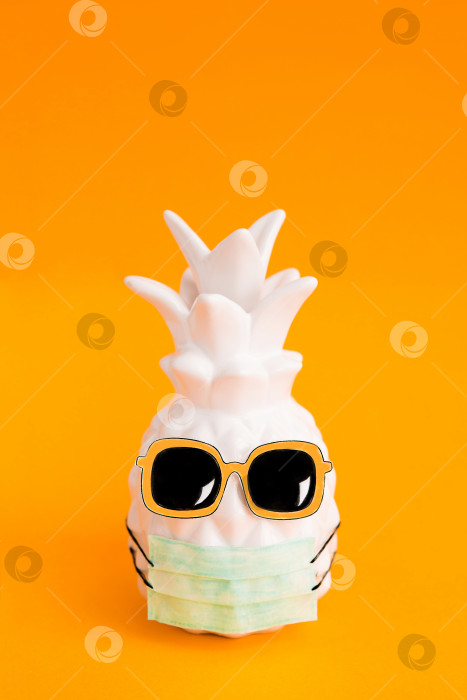 Скачать Ананас в медицинской маске и солнцезащитных очках на оранжевом фоне. Лето во время Covid-19. Видение на лето 2020 года во время пандемии коронавируса. фотосток Ozero