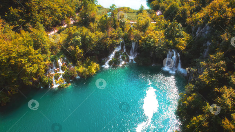 Скачать Горный водопад впадает в озеро со множеством потоков воды. Лиственный лес в национальном парке Плитвице, Хорватия. фотосток Ozero