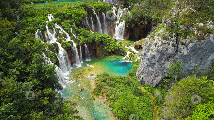 Скачать Плитвицкие водопады в горном ландшафте Хорватии. В каскадах можно увидеть синий и зеленый цвета. Водные потоки впадают в озеро. фотосток Ozero
