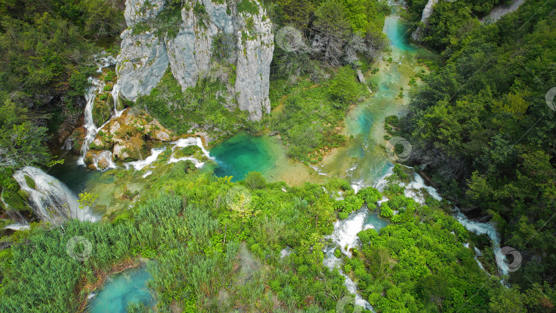 Скачать Плитвицкие водопады в горном ландшафте Хорватии. В каскадах можно увидеть синий и зеленый цвета. Водные потоки впадают в озеро. фотосток Ozero