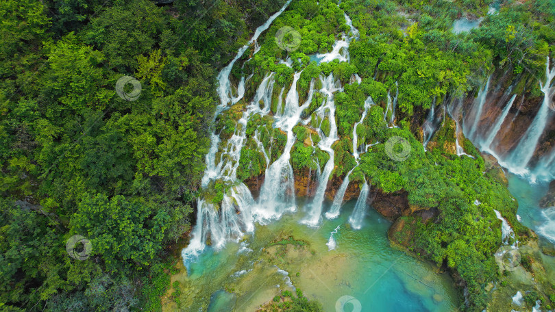 Скачать Известная туристическая достопримечательность Плитвицкие водопады в Хорватии. Горные ручьи впадают в озеро с лазурно-прозрачной водой. Летний пейзаж. фотосток Ozero