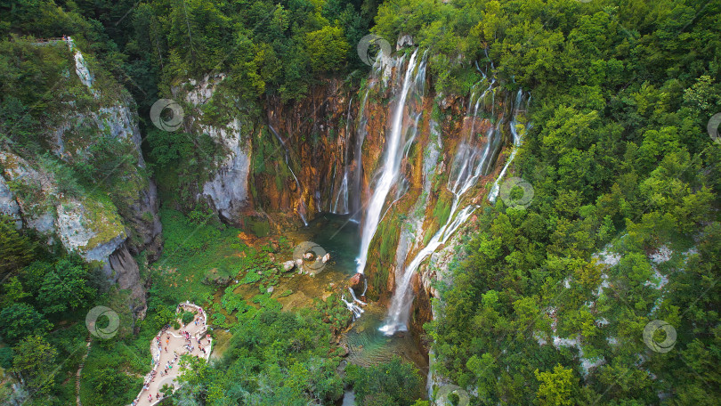 Скачать Плитвицкие водопады в Хорватии. Поток горных ручьев стекает с высокой скалы в озеро с прозрачной водой. Летний национальный парк. фотосток Ozero
