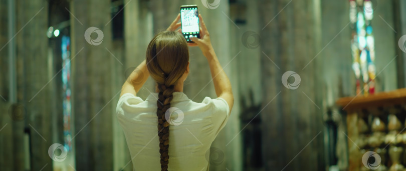 Скачать Женщина снимает архитектуру древнего здания на свой телефон. Девушка-туристка фотографируется в музее. фотосток Ozero