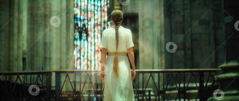 Скачать Благочестивая женщина в белом платье из мешковины ходит босиком по церкви. фотосток Ozero