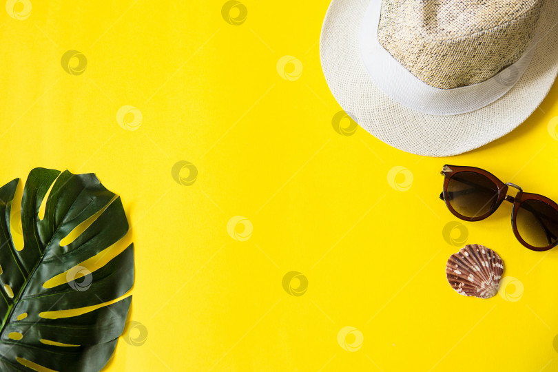 Скачать Пляжные аксессуары на желтом фоне - солнцезащитные очки и полосатая шляпа. Концепция приближающегося лета.Тропические листья монстеры. Летняя квартира, вид сверху. Место для текста. фотосток Ozero