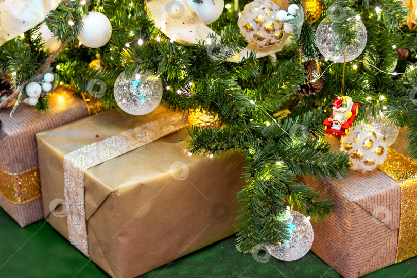 Скачать Коробки с подарками, завернутыми в крафт-бумагу, под рождественской елкой фотосток Ozero
