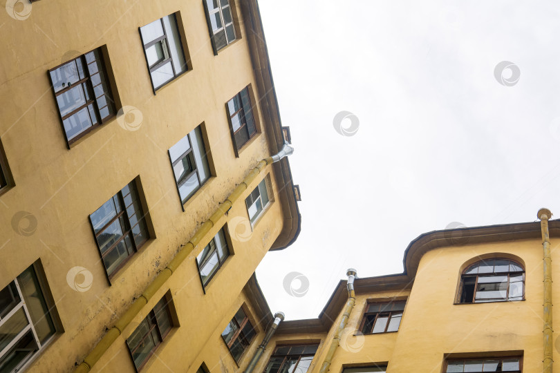 Скачать вид на верхние этажи старинных зданий из узкого и глубокого двора-колодца фотосток Ozero
