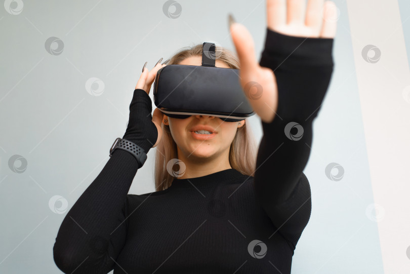 Скачать Молодая женщина в очках виртуальной реальности, VR. Девушка, использующая технологии будущего, в закрытом помещении. Новые технологии, оборудование для концепции игрового моделирования. фотосток Ozero