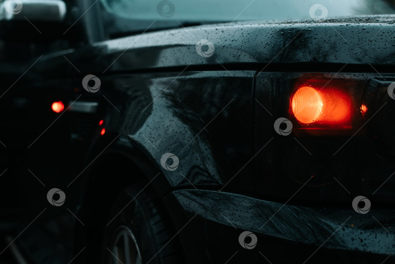 Скачать Range Rover Sport крупным планом. Черный внедорожник с каплями воды на кузове ночью на улице. Выборочная фокусировка на оранжевой фаре. Москва, Россия 12.05.2021 фотосток Ozero