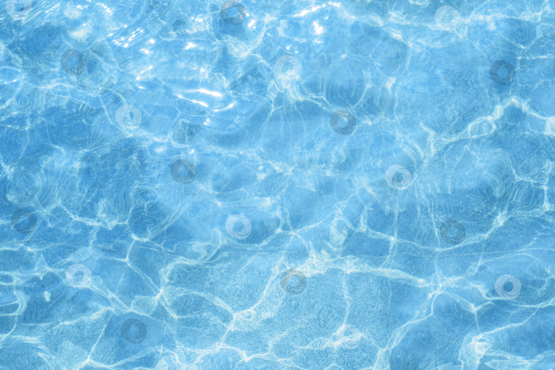 Скачать Голубая, светлая вода в бассейне снаружи. Текстура воды в солнечный день, вид сверху. Рябь и блики на поверхности бассейна. Естественный жидкий фон фотосток Ozero