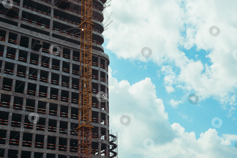 Скачать Крупный план строящегося высотного жилого дома на фоне голубого неба в солнечный день, вид снаружи фотосток Ozero