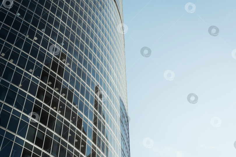 Скачать Внешний вид современного высотного офисного здания на фоне ясного голубого неба. Крупный план небоскреба в центре города. Концепция бизнеса и финансов. фотосток Ozero