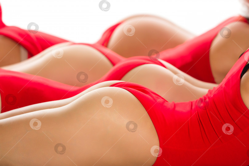 Скачать Рождество. Снимок части тела сексуальных женских ягодиц в красных купальниках, изолированных на белом фоне фотосток Ozero