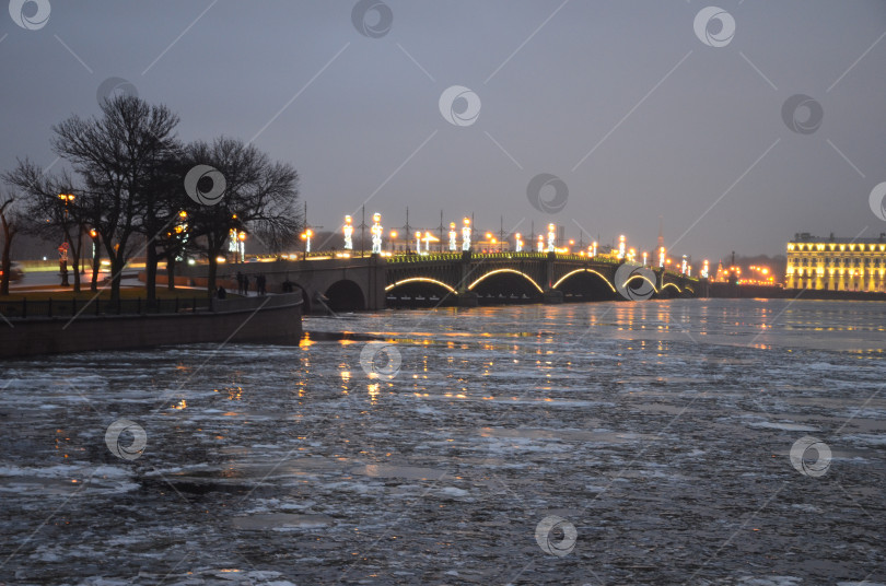 Скачать Троицкий мост, украшенный к Новому году на фоне реки Невы с потрескавшимся льдом фотосток Ozero